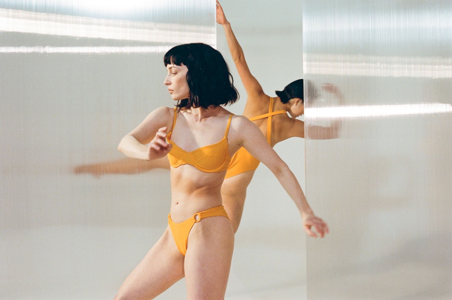 two models dancing in yellow OOKIOH swimwear