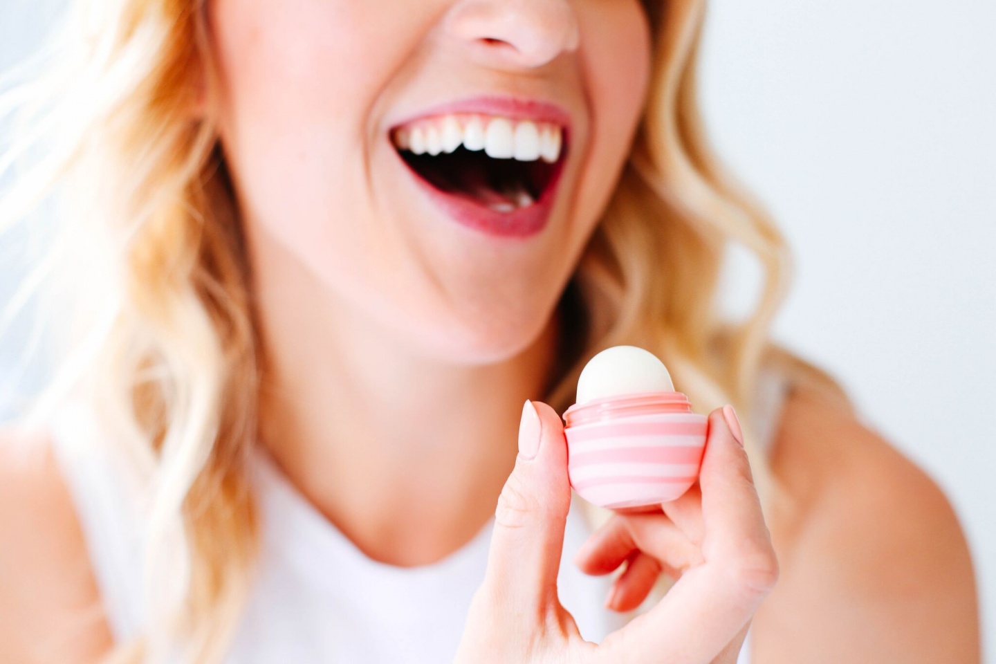 model smiling with EOS lip balm